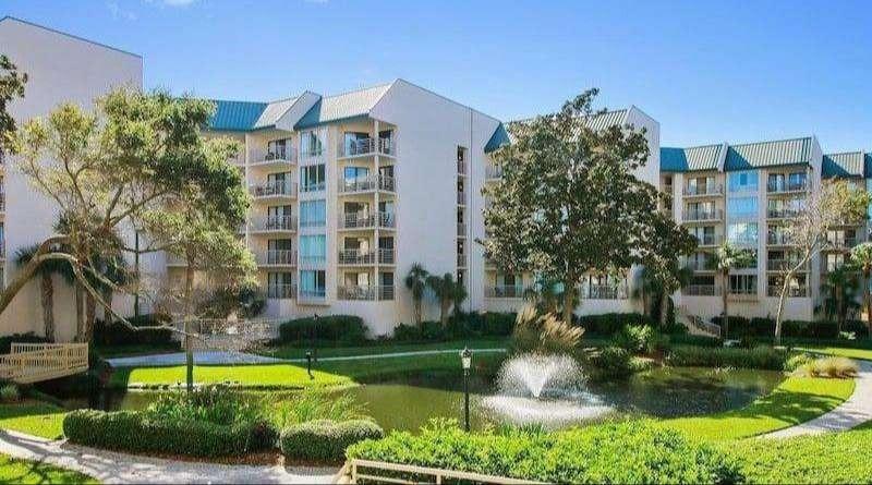 Large, multi-story oceanfront resort complex with numerous balconies and windows.