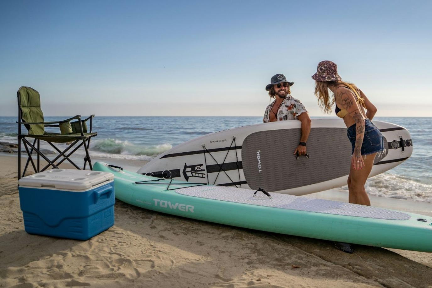 A man and woman paddleboarding and kayaking in the ocean.