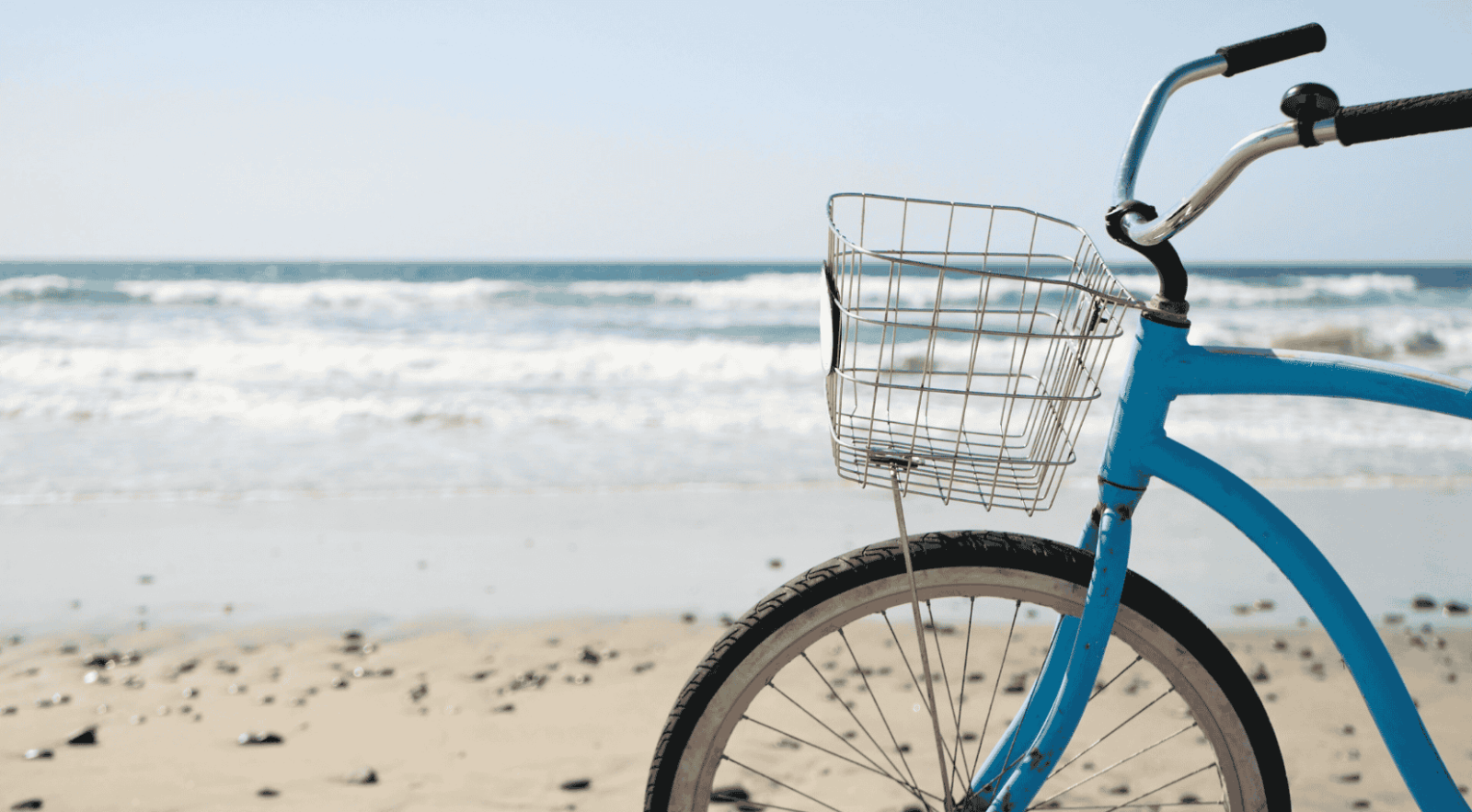 beach cruiser bike parked on a sandy beach with the ocean in the background